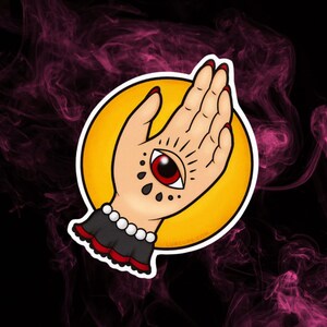 May include: A stylized illustration of a hand with an all-seeing eye on the palm. The hand is in a praying position with red nail polish. The background is a yellow circle with a white outline.