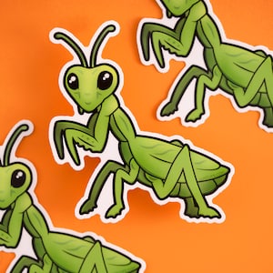 May include: Three green cartoon praying mantis stickers with white outlines. The mantises are in various poses with their legs outstretched. The stickers are on a bright orange background.