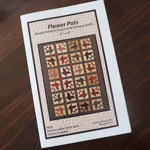 May include: A quilting pattern booklet with a colorful quilt design on the cover. The title is "Flower Pots" and the text says "Simple Patterns Inspired by Antique Quilts 31" x 23" PLUS Garden Ladies Petite Quilt Pattern Included petitequilts.etsy.com copyright 2014".