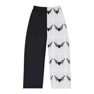 Può includere: Pantaloni da pigiama a gamba larga con un design diviso sorprendente. Una gamba è nera tinta unita, mentre l'altra è bianca con un motivo ripetuto di disegni neri a forma di cuore con accenti a forma di ala. I pantaloni hanno una vestibilità comoda e rilassata.