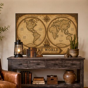 Puede incluir: Una impresión de arte mural rectangular que presenta un mapa del mundo de estilo vintage en tonos sepia. El mapa muestra los hemisferios occidental y oriental, una rosa de los vientos y un velero. El texto dice THE WORLD DISCOVER ADVENTURE.