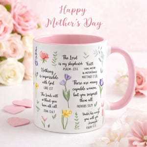 May include: White ceramic mug with a pink interior and handle, decorated with floral illustrations and inspirational quotes. The mug has the text "Happy Mother's Day" and Bible verses. Perfect for gifting.
