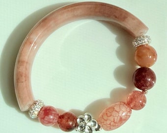 Bracciale rigido a mezzo bracciale fatto a mano color malva polveroso, con arco di pietra traslucida, perline di pietre preziose e dettagli scintillanti.