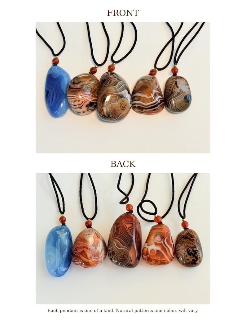 May include: A collection of six gemstone pendants with black cords. The pendants display a variety of colors and patterns, including blue, brown, and orange. Each pendant is unique. The text reads: "Each pendant is one of a kind. Natural patterns and colors will vary."