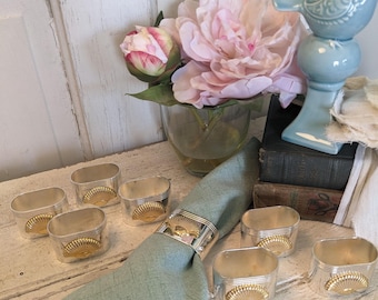 Juego de 8 servilleteros vintage bañados en plata con detalle de concha marina de latón