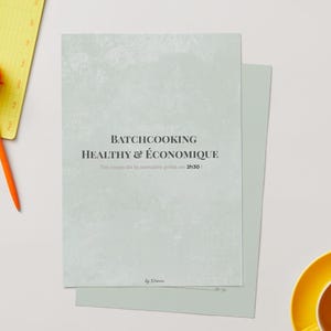 Puede incluir: Un libro de recetas verde claro con el título "BATCHCOOKING HEALTHY & ÉCONOMIQUE" en texto negro. El texto "Vos repas de la semaine prêts en 2h30" está debajo del título. Un bloc de notas amarillo y un bolígrafo naranja están en el fondo.