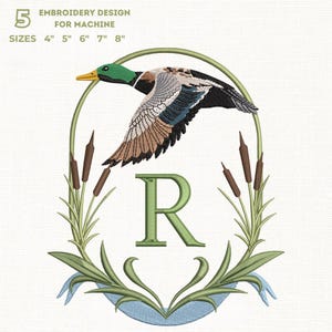 Può includere: Un disegno di ricamo per macchina, con un'anatra in volo con piume verdi e marroni, all'interno di una cornice ovale verde. Il disegno include la lettera "R", giunchi e il testo "EMBROIDERY DESIGN FOR MACHINE" e misure da 10 cm a 20 cm.