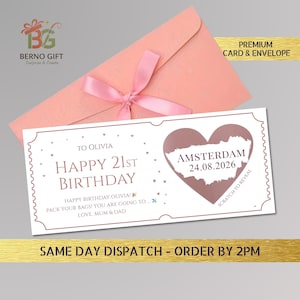 May include: A birthday card with a pink envelope and ribbon. The card reads "Happy 21st Birthday" with "Amsterdam 24.08.2026" inside a heart. The card is white with a decorative border.
