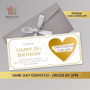 May include: A white birthday card with gold accents and a gold heart-shaped scratch-off area. The card reads "Happy 21st Birthday Olivia" and includes the text "Amsterdam 24.08.2026". It is paired with a gray envelope and a white ribbon.