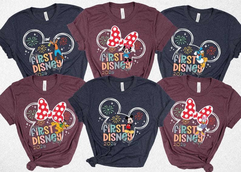 May include: A collection of six short-sleeved t-shirts. Each shirt features a colorful graphic with the text "First Disney 2020" and a Mickey Mouse head design. The shirts are in various colors, including navy blue and burgundy.
