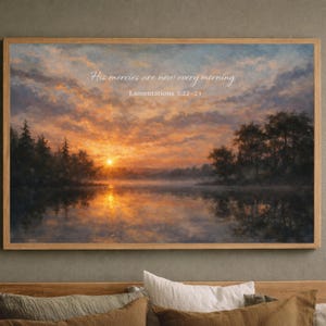May include: A framed landscape painting depicts a sunrise over a lake, with the text "His mercies are new every morning" and "Lamentations 3:22-23". The artwork features a warm color palette of orange, yellow, and blue, with trees silhouetted against the sky.