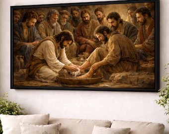 May include: A framed artwork depicting a biblical scene. The image shows a group of men, with one washing the feet of another. The artwork is rendered in warm, earthy tones, with a focus on the figures and their expressions. The frame is black.