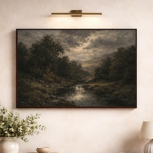 May include: A framed landscape painting depicts a serene river scene under a cloudy sky. The artwork features dark green trees and foliage along the riverbanks, with a brown frame. The painting is mounted on a light-colored wall.