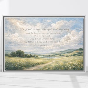 Könnte beinhalten: Gerahmter Kunstdruck mit einer ruhigen Wiesenlandschaft unter einem bewölkten Himmel. Das Kunstwerk enthält ein Zitat aus Exodus 15:2: "Der Herr ist meine Stärke und mein Lied..." Der Druck hat einen weißen Rahmen.