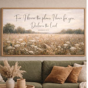 Può includere: Una stampa incorniciata raffigurante un campo di fiori selvatici ed erba alta sotto un cielo nuvoloso. L'opera d'arte include il testo "For I know the plans I have for you. Declares the Lord. Jeremiah 29:11" in elegante scrittura.