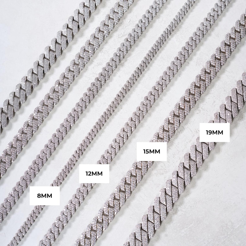 K&ouml;nnte beinhalten: Eine Auswahl an silberfarbenen Panzerketten in verschiedenen Breiten, darunter 8 mm, 12 mm, 15 mm und 19 mm. Die Ketten sind diagonal vor einem hellen Hintergrund angeordnet und zeigen ihr detailliertes Design und ihre reflektierenden Oberfl&auml;chen.