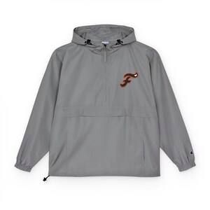 May include: A gray anorak jacket with a hood and a half-zip closure. The jacket features a black and orange embroidered "F" logo on the chest. The jacket has a front pocket and a drawstring at the hem.