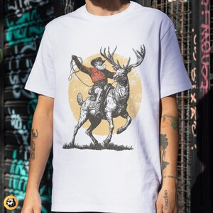 Western Christmas Cowboy Santa Clipart, Vintage Rodeo Reindeer T-shirt Design, Distressed Farmhouse Christmas PNG SVG, Retro Engraving Style Digital Download, Rustic Outlaw Santa Sublimation, Unique Holiday Graphic Tee File, Engraved Reindeer Rider Art, Muted Color Retro Christmas Print, Christmas Shirt Maker Resource, Cowboy Santa Riding Elk Drawing.