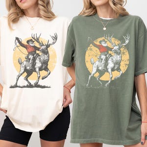 Western Christmas Cowboy Santa Clipart, Vintage Rodeo Reindeer T-shirt Design, Distressed Farmhouse Christmas PNG SVG, Retro Engraving Style Digital Download, Rustic Outlaw Santa Sublimation, Unique Holiday Graphic Tee File, Engraved Reindeer Rider Art, Muted Color Retro Christmas Print, Christmas Shirt Maker Resource, Cowboy Santa Riding Elk Drawing.