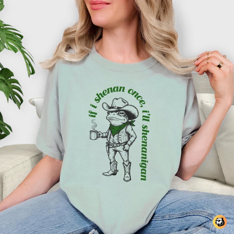funny frog cowboy st patricks day png, retro shenanigan frog shirt design, vintage western irish green frog, frog riding cowboy funny illustration, st paddys day green frog art, distressed green cowboy frog sublimation, whimsical irish shenanigan digital download, lucky frog cowboy hat western png, funny st patricks day humor for adults, vintage woodcut style frog cowboy design