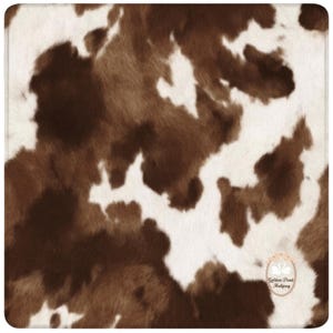 May include: A square, cowhide-patterned textile featuring a mix of brown and white patches. The design mimics the natural look of animal hide, with irregular shapes and textures. The edges are finished with a subtle, stitched border.