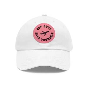 May include: White baseball cap with a pink circle patch that says "Off Duty Save Yourself" with a plane icon in the center.