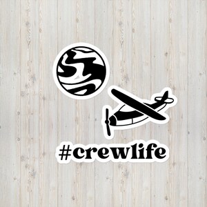 Può includere: Set di adesivi in bianco e nero con un pianeta, un piccolo aereo e il testo "#crewlife".