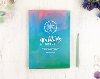 Puede incluir: Un diario de acuarela azul y verde con un diseño geométrico blanco y el texto "gratitude journal" y "mind shifting exercises to feel happy, positive & loved" y "thehappiempire".