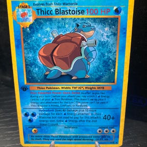 Puede incluir: Una carta de Pokémon Thicc Blastoise con un diseño azul y amarillo. La carta presenta un Blastoise de dibujos animados con una gran parte trasera. La carta tiene el texto "Thicc Blastoise 100 HP" y otros detalles del juego.