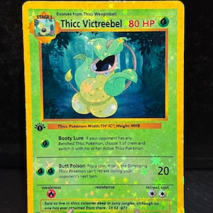 以下が含まれることがあります： ホログラフィック Thicc Victreebel ポケモンカード。カードは、中央にキャラクターがいる緑と黄色の配色です。カードテキストには「Booty Lure」と「Butt Poison」が含まれています。