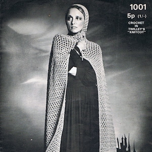 May include: A black and white photo of a woman wearing a crocheted hooded cape. The cape is a light gray color and has a lacy pattern. The woman is standing in front of a dark background. The text "1001 5p (1/-) CROCHET IN TWILLEY'S "KNITCOT"" is printed in the top right corner of the image.