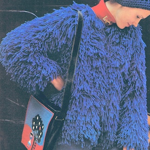 Op de afbeelding: Een blauw, pluche jack met een zwarte schouderband en een kleurrijke tas met een boomontwerp.