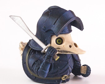 Puede incluir: Una figura de un guerrero con rostro de calavera de pájaro con armadura azul oscuro, sosteniendo una espada plateada. La figura tiene un casco y una coraza detallados, con una hebilla dorada. La calavera de pájaro tiene ojos verdes.
