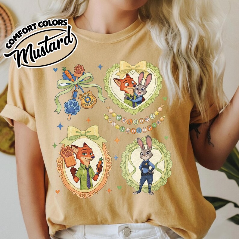 May include: A mustard yellow t-shirt featuring a graphic print of Zootopia characters Nick Wilde and Judy Hopps. The design includes framed illustrations, a police badge, a paw-shaped popsicle, and the text Welcome to Zootopia.
