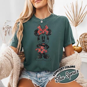 May include: Blue Spruce t-shirt with a distressed Minnie Mouse graphic, sporting a red polka dot bow and dress. The shirt features the words "COMFORT COLORS" and "Blue Spruce" in a circular design.
