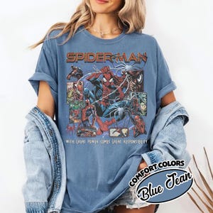 K&ouml;nnte beinhalten: Blaues T-Shirt mit einem Spider-Man-Motiv, Comic-Panels und dem Text "SPIDER-MAN" und "WITH GREAT POWER COMES GREAT RESPONSIBILITY." Das Shirt ist ein Comfort Colors Blue Jean.