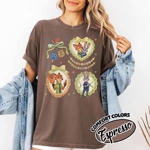 May include: A dark brown short-sleeve t-shirt featuring a graphic print of two animated animal characters in ornate frames, a police badge, and a carrot-shaped popsicle. The text COMFORT COLORS Espresso is printed in a black oval at the bottom right.