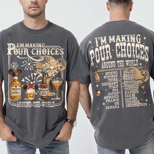 May include: Dark gray t-shirt with the text "I'M MAKING POUR CHOICES AROUND THE WORLD." The front features cartoon illustrations of Mickey Mouse and Donald Duck-themed drinks. The back lists countries and drinking toasts.