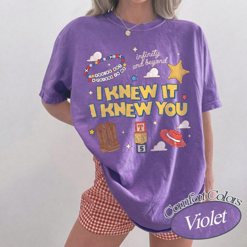 May include: A violet short-sleeve t-shirt featuring the yellow text I KNEW IT I KNEW YOU, a beaded bracelet graphic with the text YOU'VE GOT A FRIEND IN ME, a sheriff star, cowboy boots, alphabet blocks, and a red hat with the text infinity and beyond.