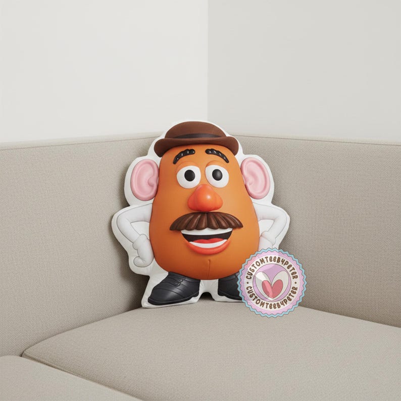 Peut inclure: Un coussin Mr. Patate en orange, marron et blanc. Le coussin pr&eacute;sente un chapeau marron, une moustache et des chaussures noires. Le coussin est sur un canap&eacute; beige. Un autocollant avec le texte "CUSTOMTEE4PETER" est sur le canap&eacute;.