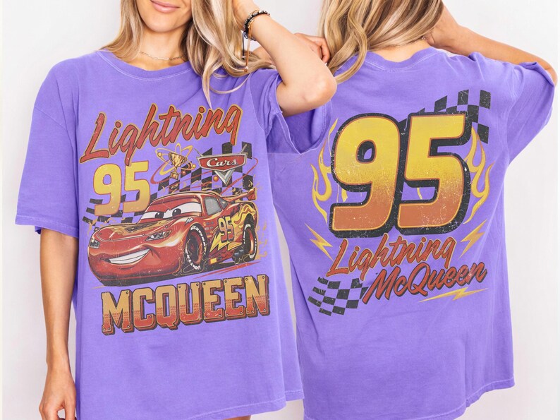 Puede incluir: Camiseta morada con Lightning McQueen de la pel&iacute;cula Cars. El dise&ntilde;o frontal incluye "Lightning 95 McQueen" y una imagen del coche. La parte trasera muestra un gran "95" con "Lightning McQueen" debajo.