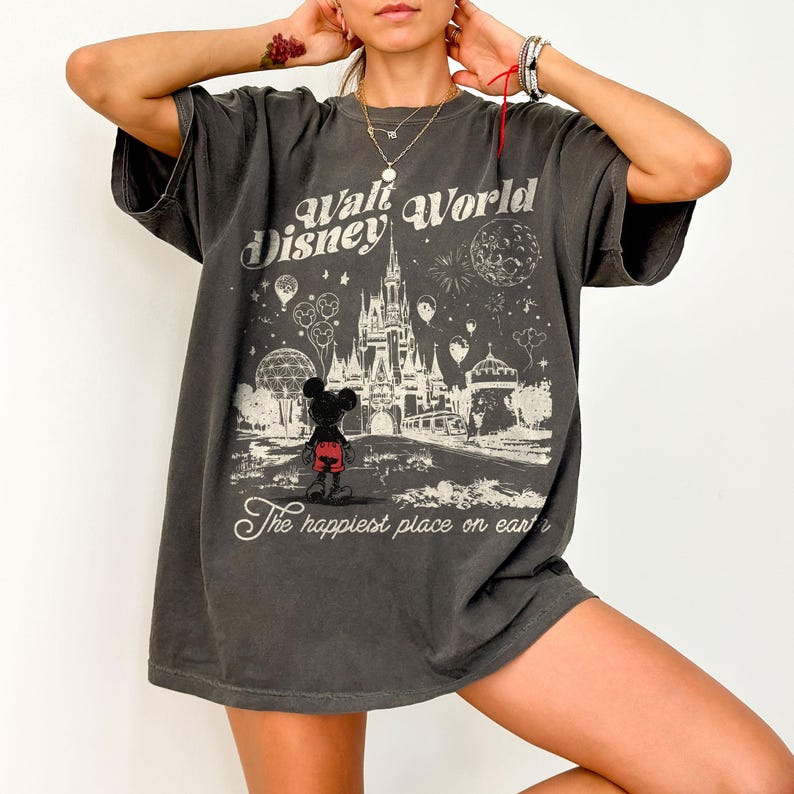 Peut inclure: T-shirt gris fonc&eacute; avec un motif vintage de Walt Disney World. Le design comprend le ch&acirc;teau Disney, Mickey Mouse et le texte "The happiest place on earth."
