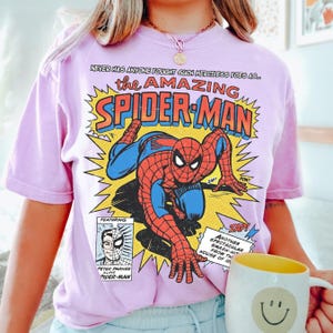 以下が含まれることがあります： 黒いハンドルと「But First, Coffee」のテキストが黒い太字で書かれた白いセラミックマグ。マグは白い表面に置かれています。