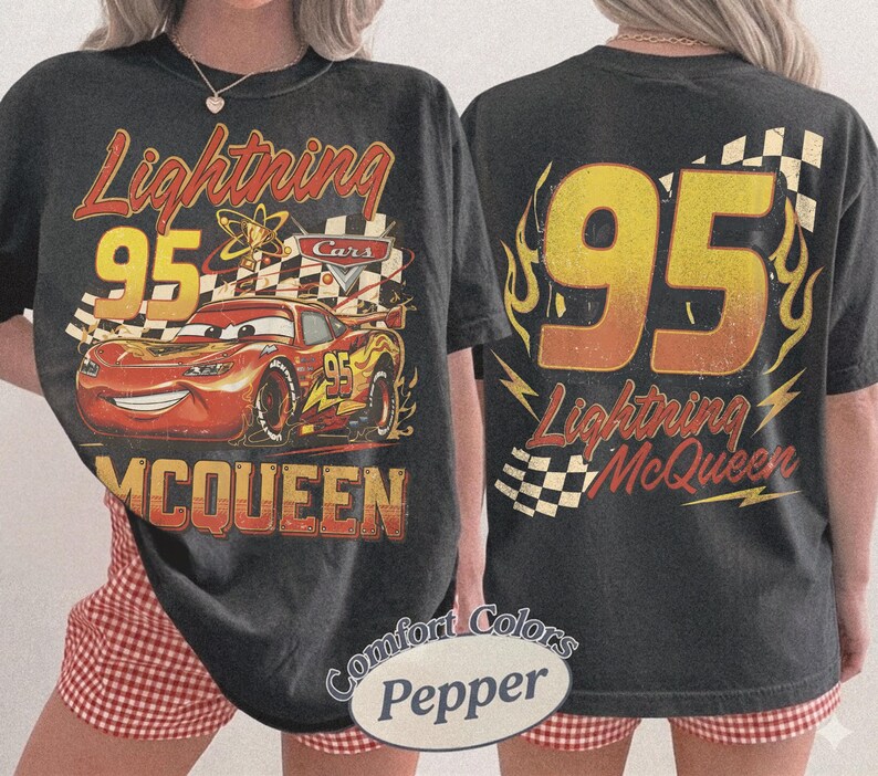 Puede incluir: Camiseta gris oscuro con Lightning McQueen de la pel&iacute;cula Cars. El gr&aacute;fico frontal muestra a McQueen con el n&uacute;mero 95, una bandera a cuadros y el texto "Lightning McQueen". La parte trasera muestra un gran "95" con llamas y el texto "Lightning McQueen".