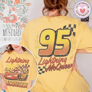 Puede incluir: Camiseta de color mostaza con un dise&ntilde;o de Rayo McQueen de la pel&iacute;cula Cars. El dise&ntilde;o frontal incluye el coche y texto, mientras que la parte trasera muestra un gran "95" con llamas y texto "Lightning McQueen".