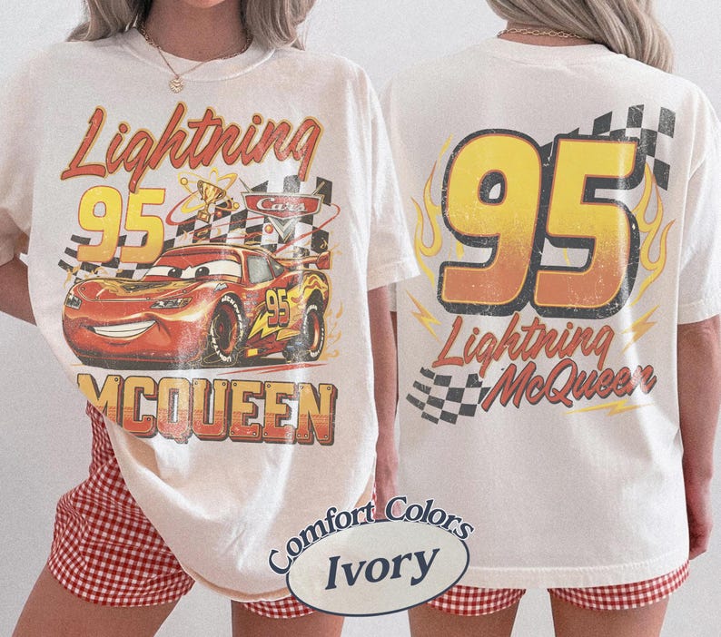 Puede incluir: Camiseta color marfil con un dise&ntilde;o de Rayo McQueen de la pel&iacute;cula Cars. La parte delantera muestra el coche con el texto "Lightning 95 McQueen". La parte trasera muestra "95 Lightning McQueen" con llamas y un dise&ntilde;o de bandera a cuadros.