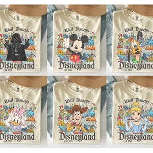 May include: Cream-colored t-shirts featuring various Disney characters and the Disneyland logo. Characters include Darth Vader, Mickey Mouse, Pluto, Daisy Duck, Woody, and Cinderella. Each shirt has the text "Walt Disney's Disneyland Est 1955".
