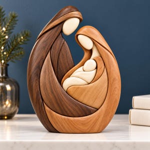 May include: A smooth, abstract wooden sculpture depicting a family of three figures in an embrace. The piece features contrasting light and dark wood grains, with curved, flowing lines forming the silhouettes of two adults and a small infant.