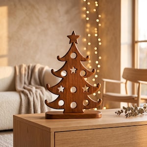 Peut inclure: Une décoration de sapin de Noël en bois brun avec une étoile au sommet et plusieurs découpes circulaires et en forme d'étoile sur tout le corps. L'arbre est monté sur une base rectangulaire en bois et présente une finition lisse et polie.