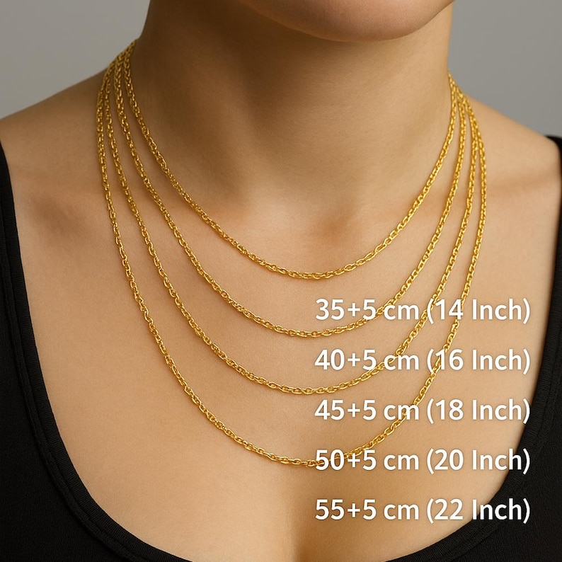 May include: Gold-colored chain necklaces of varying lengths are displayed. The necklaces are shown in 14, 16, 18, 20, and 22-inch lengths, with corresponding centimeter measurements. The chains are worn around the neck, showcasing the different lengths.